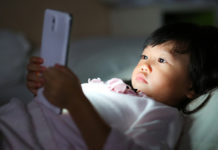 “Virtual Autism” May Explain Explosive Rise in ASD Diagnoses child looking at smartphone