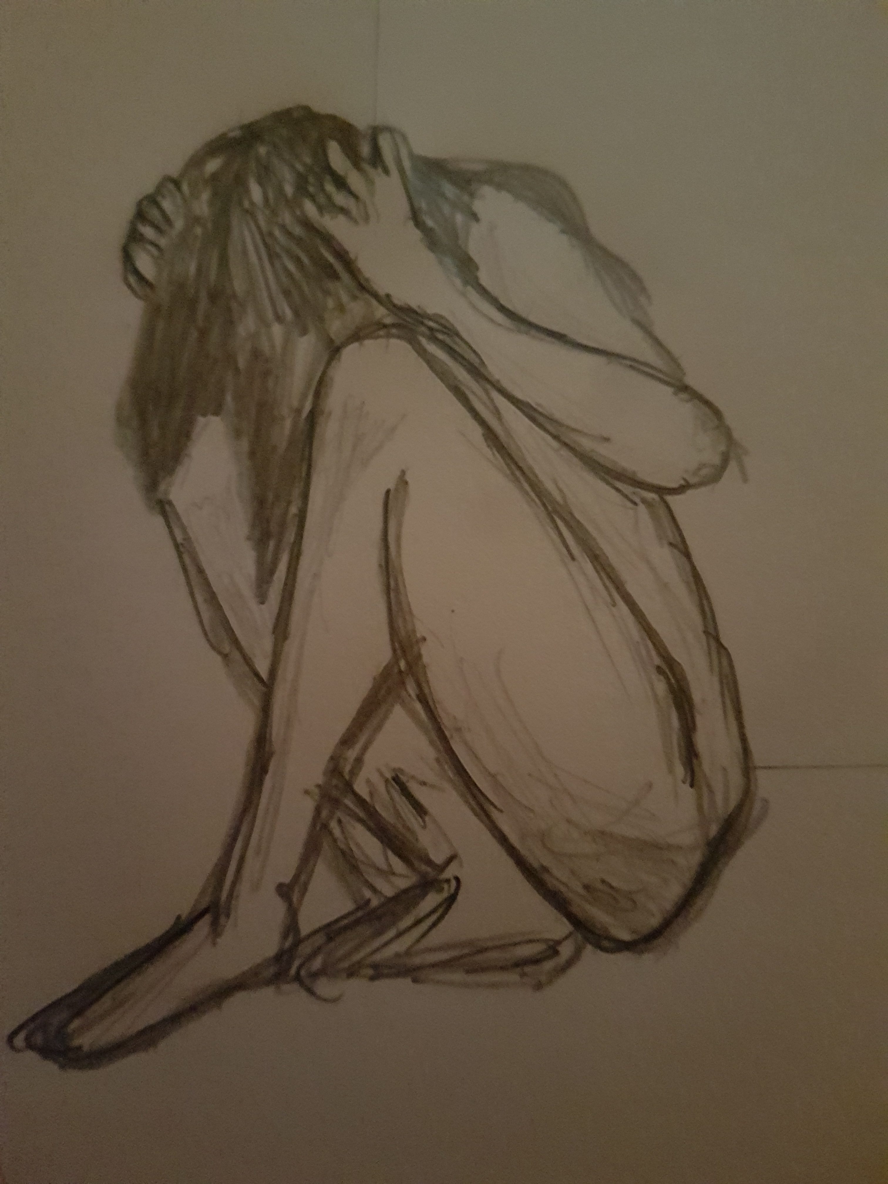 Person with knees pulled towards their chest and hands in hair