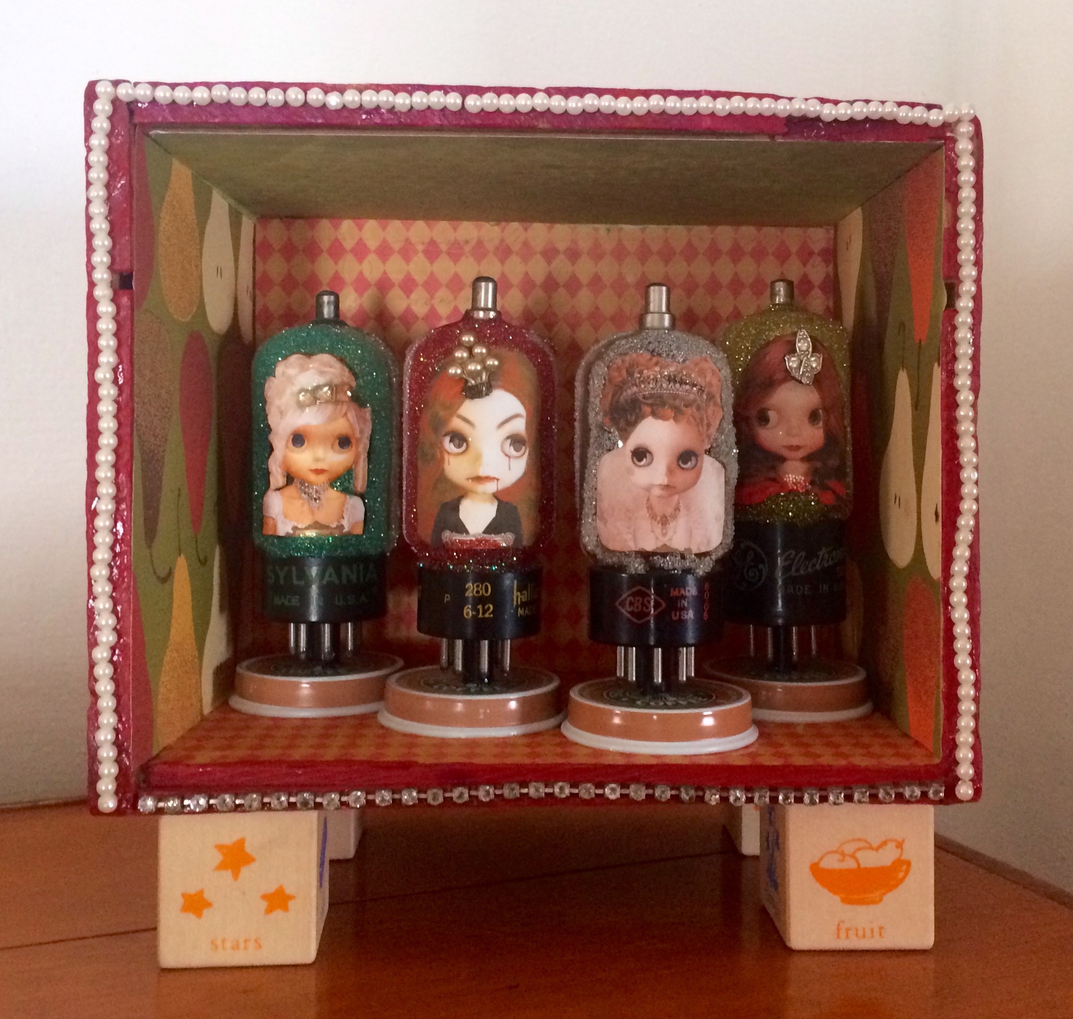 Four girls encapsulated in glitter in a shadow box