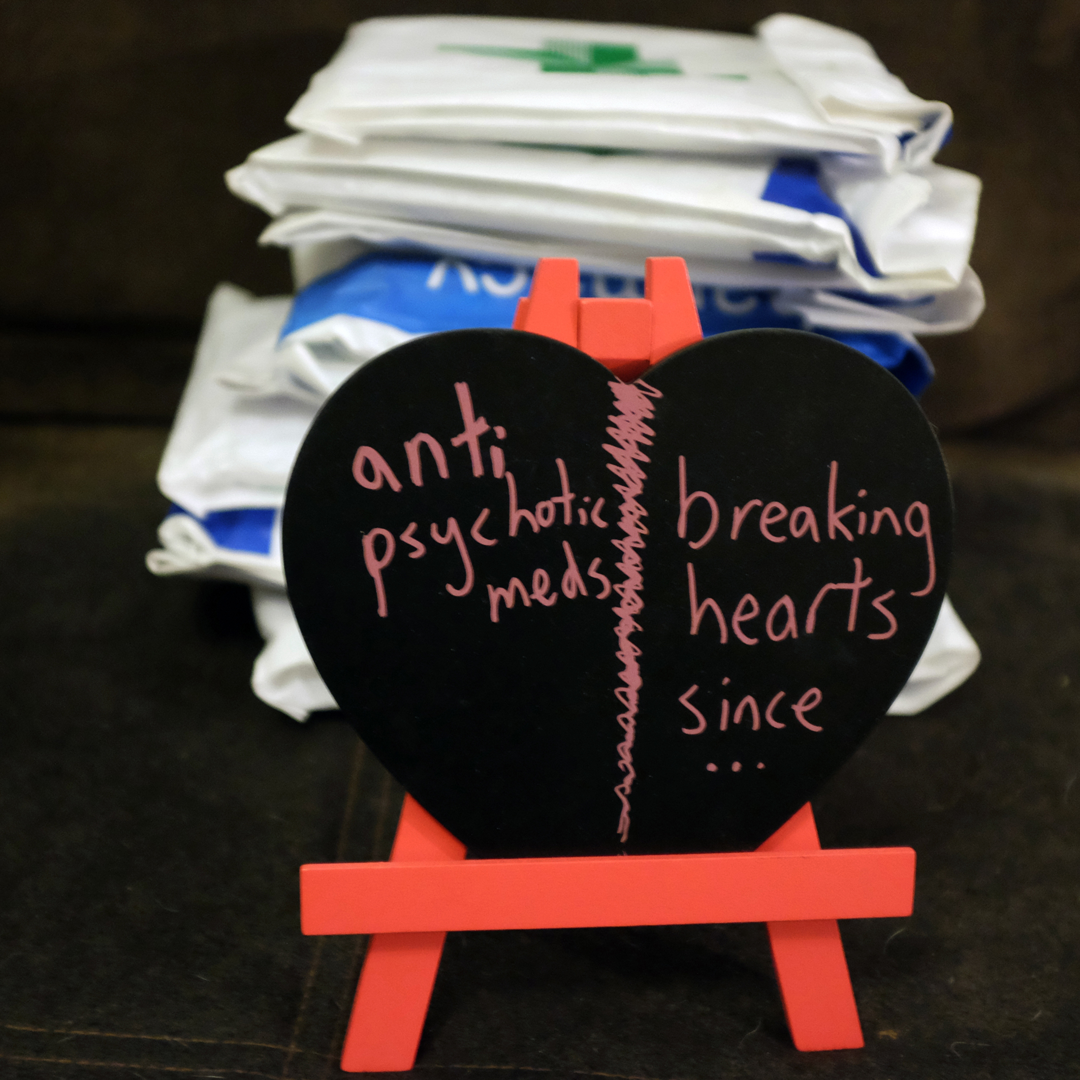 Black heart in a canvas with text "Antipsychotic Meds - Breaking Hearts Since...'