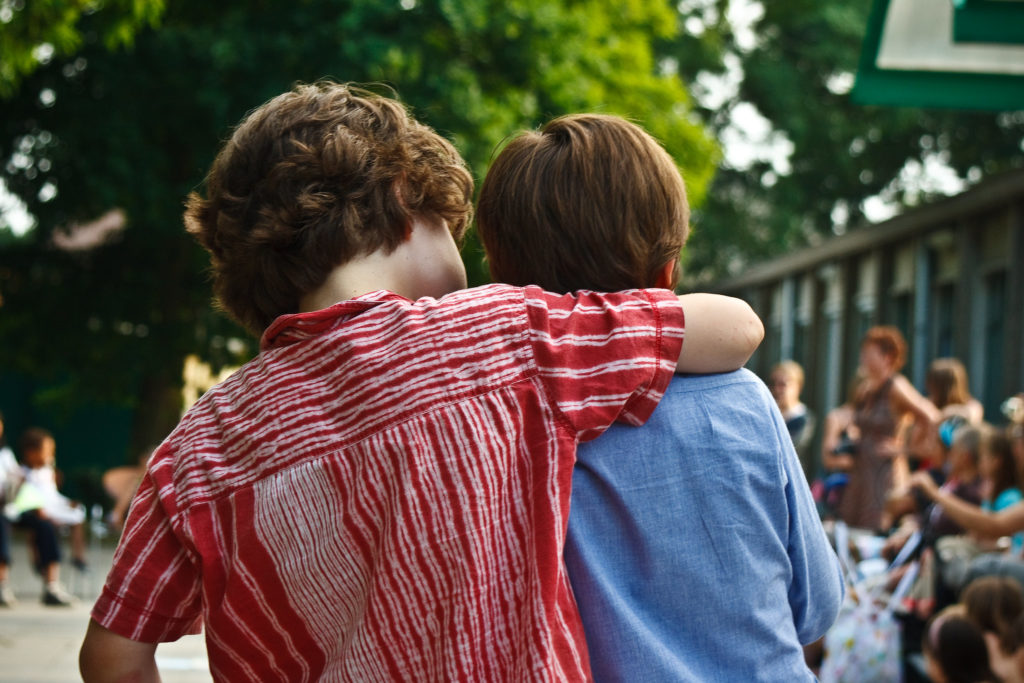 two boys hugging from back