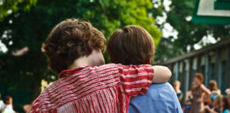Study Links Emotional Intelligence and School Achievement two boys hugging from back
