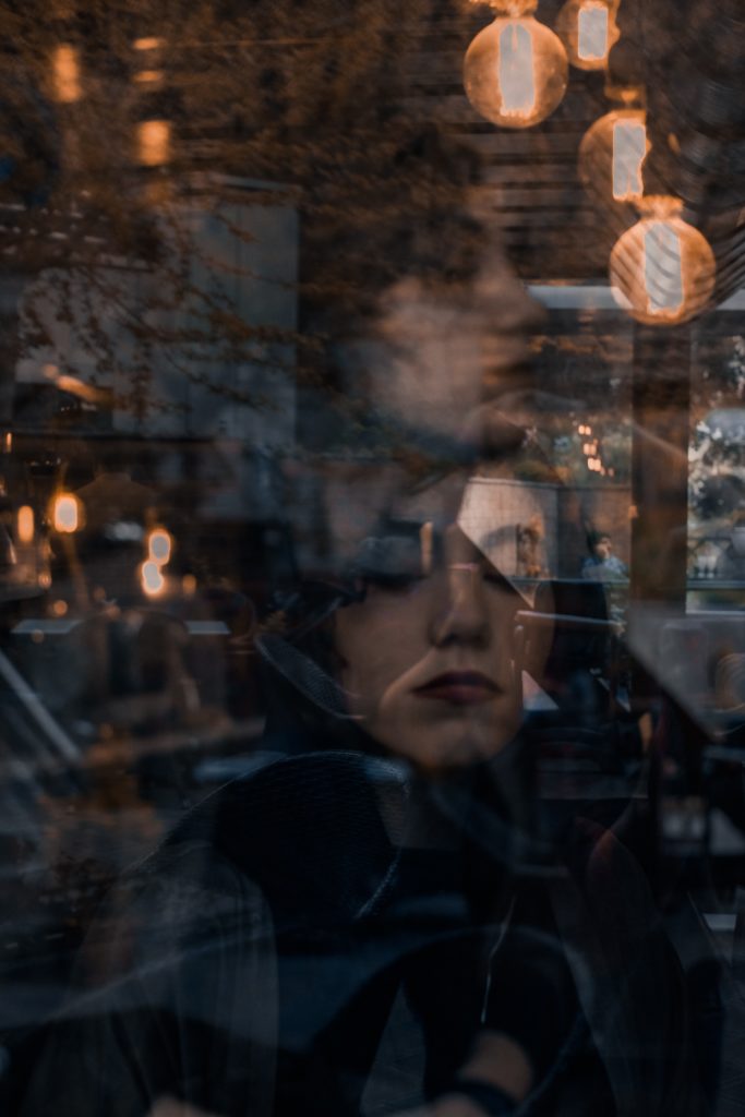 Woman reflected and visible behind glass