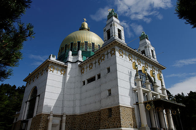 Image of the Kirche am Steinhof, also called the Church of St. Leopold, Steinhof institution in Vienna, a white building with ornate gold dome and decorative elements.