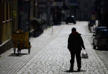 Coronavirus, Anxiety, and the Profound Failure of Rugged Individualism A person with a grocery bag stands alone in a street.