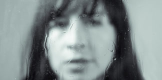 6 Ways Trauma Might Inform Your Current Life woman out of focus with rain on glass