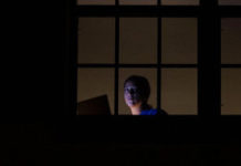 People Financially Affected by COVID-19 Experience More Psychological Distress than Others woman alone on her laptop behind a window
