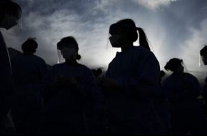 health care workers wearing PPE in silhouette.