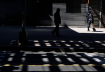 Experts Warn of Mental Health Fallout from Mass U.S. Unemployment a person stands alone in silhouette in the shadows