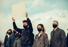 Mad in America and Activism crowd in masks with signs