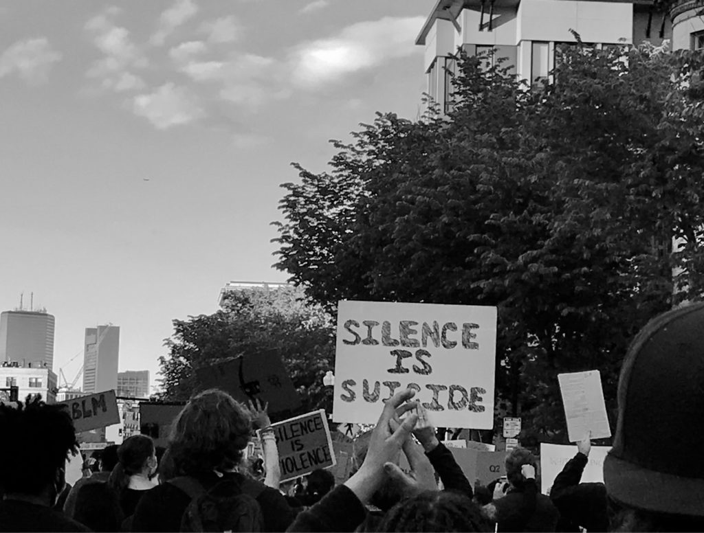 protesters with a sign reading "silence is suicide"