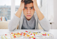 SSRI Withdrawal’s Elephant in the Room: Tardive Akathisia man looking upset with pills in front of him