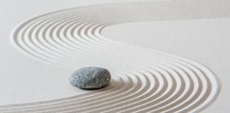 How Mindful Awareness Can Reduce Suffering stone in zen sand garden