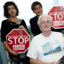 John McCarthy with two activists holding “Stop Forced Treatment” signs