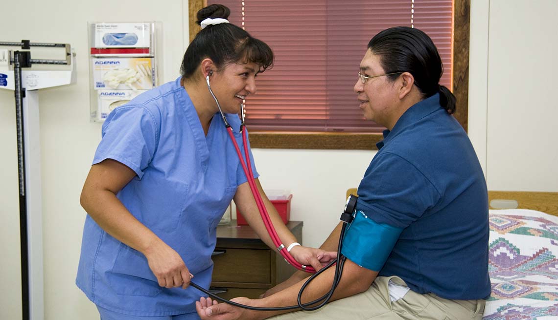 A Native American nurse takes a patients blood pressure during a routine physical examination at an Indian Health Center.