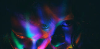 Photograph of two faces in psychedelic colors with dark background