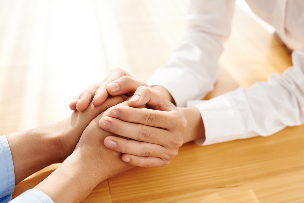 Close up photo of hands being held