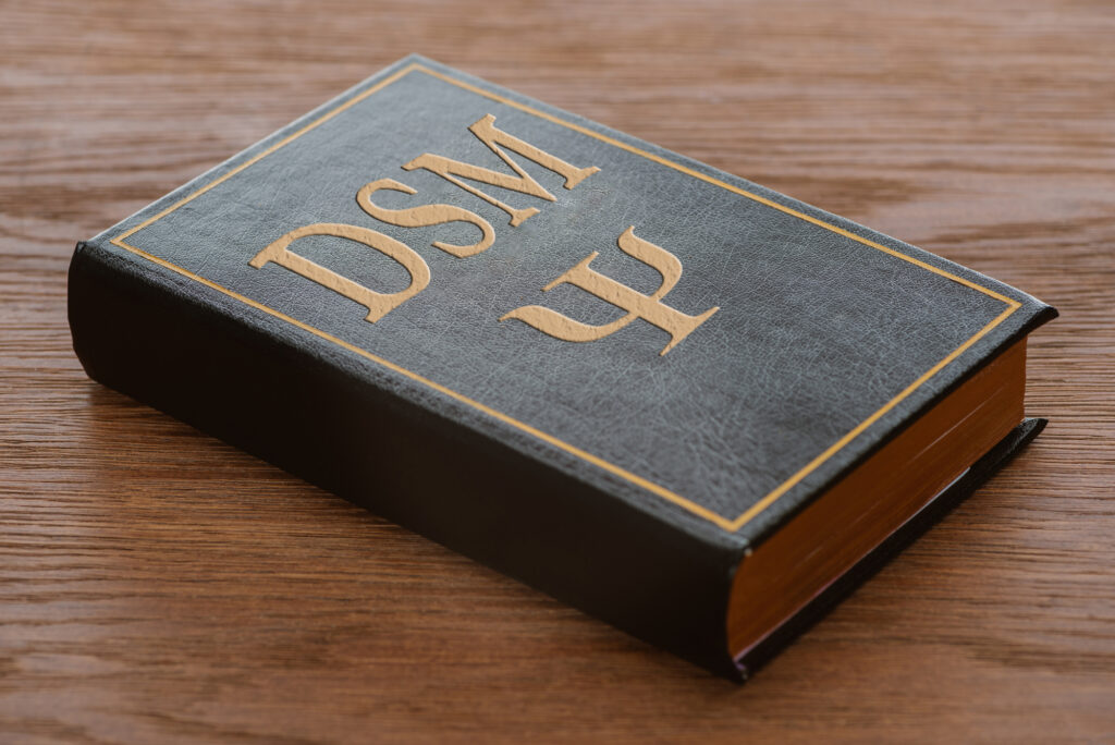 A Bible-like book with "DSM" embossed on the cover