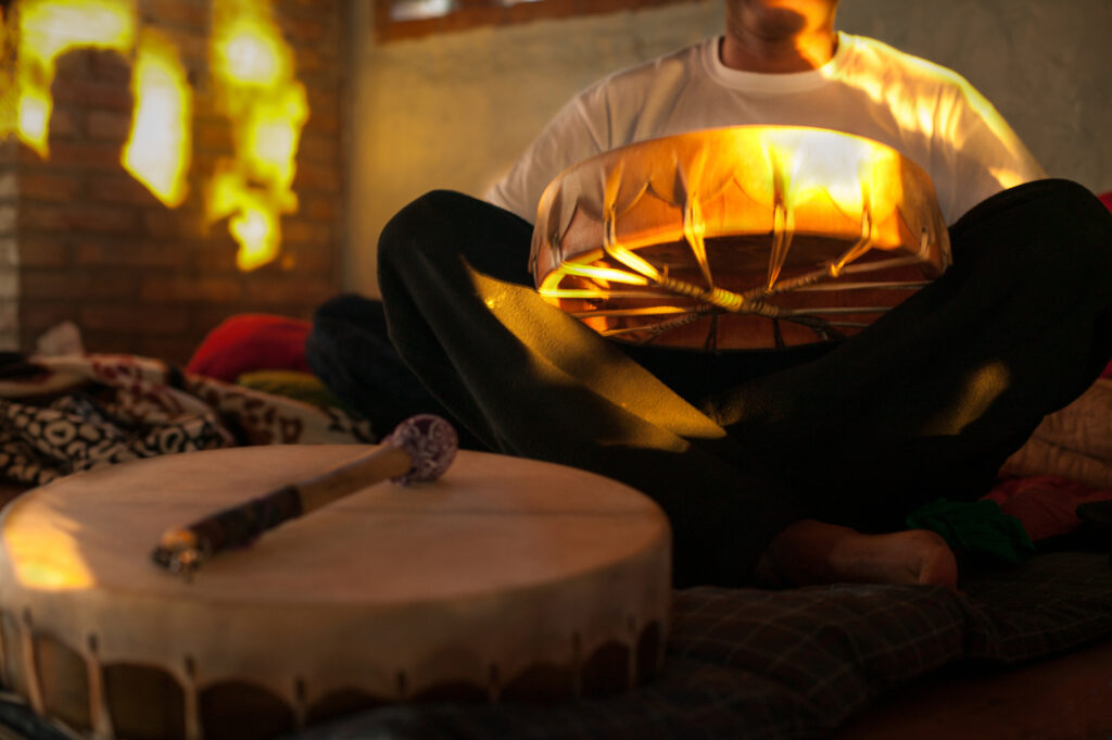 Detail of a drum on the ground and the other in the hands of a player: The music that is played afd a ceremony with the use of ayahuasca