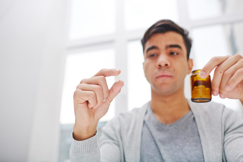 guy holding pill