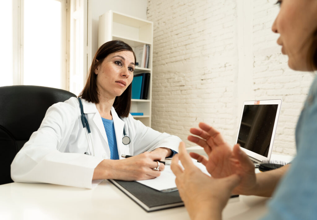 Female family doctor listening carefully to woman patient.