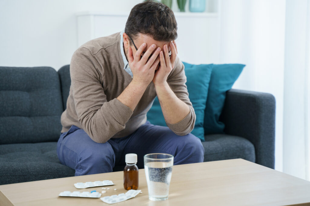 Picture of distressed man facing pills