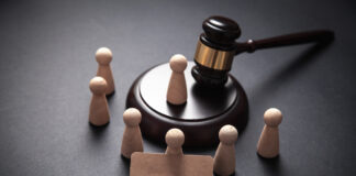 Guardianship Destroyed My Family Wooden pawn-like figures surrounding a gavel