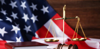 Malignant Do-Gooderism: The Tragedies of Allopathic Psychiatry Judge gavel with scales, books and american flag on wooden table