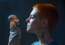 Can the Psychodynamic Manual Move Therapy Beyond the DSM? Against a dark background, profile of a young woman, the gaze which is directed at the doll depicting of Freud.