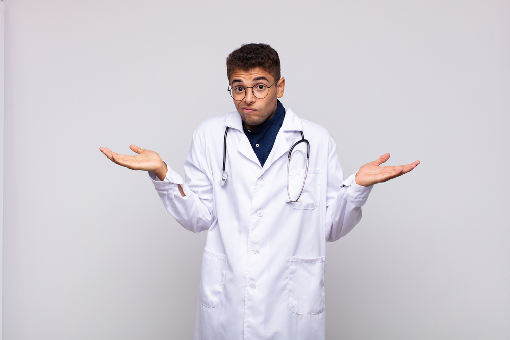 young physician man feeling puzzled and confused