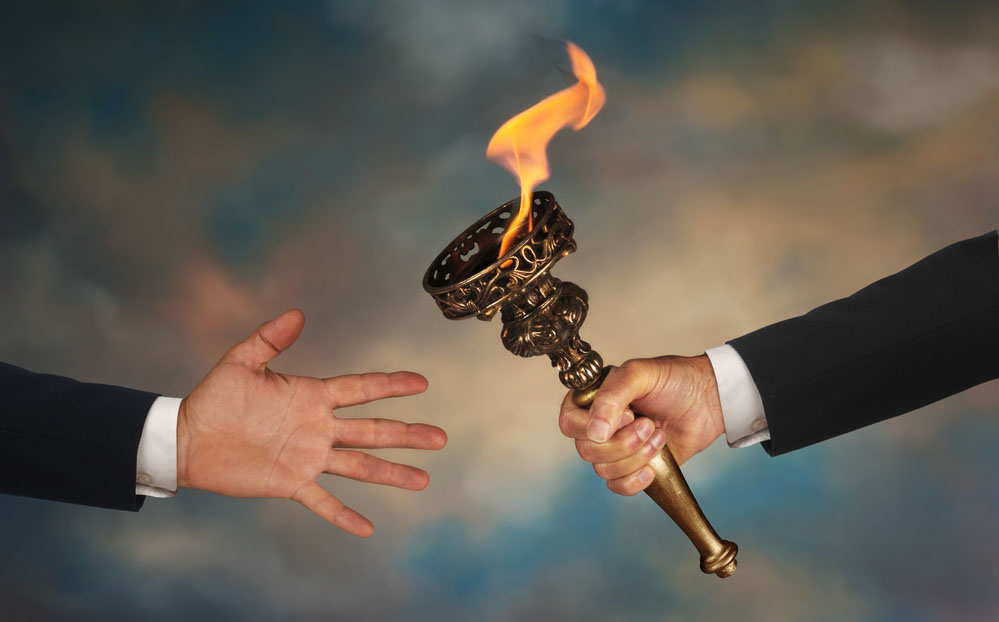 Passing a flaming torch to another open hand