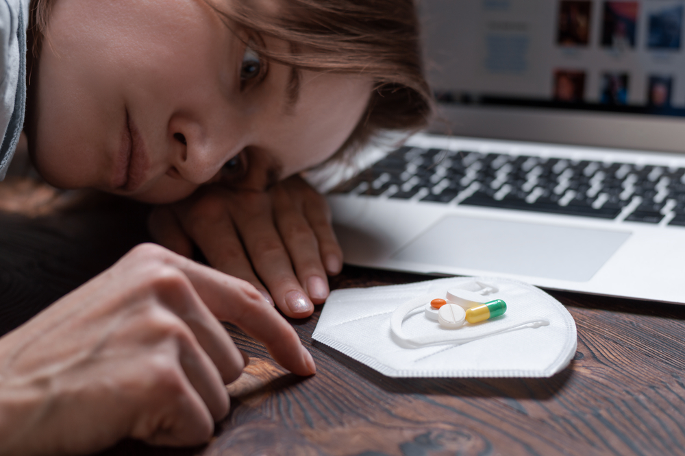 Image of a young girl looking at a handful of antidepressants.