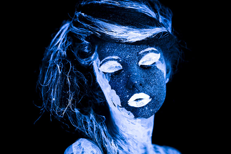 Photo of a face painted, glowing in ultraviolet light