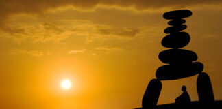 Inside a Forensic Psychiatry Unit: Cultivating the Superpower of Equanimity Silhouette against sunset: A person sits and meditates under a tower of stones