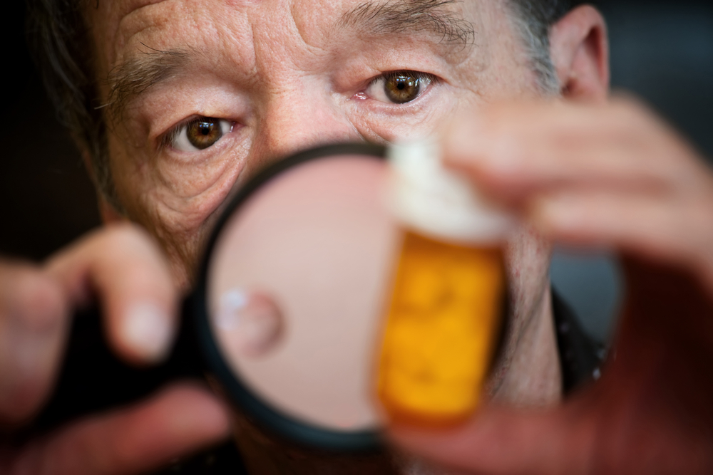 Man closely examing instructions on prescription medications