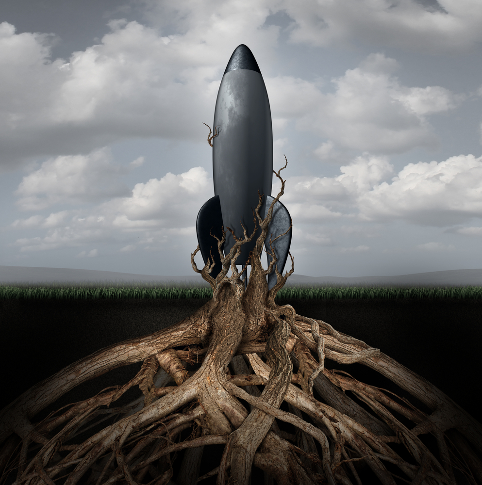 Rooted down concept with an aging rocket ship being held down by growing tree roots