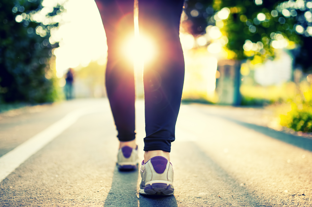 Close-up of woman athlete feet and shoes while running in park.