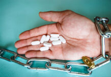 Behavior Therapy Helped My Patients Through Antidepressant Withdrawal A hand chained in a chain holds pills