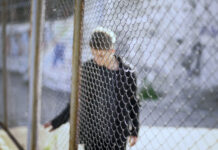 Troubled Teen Industry Packages Abuse as Treatment Teen boy behind fence confinement, boarding school restrictions, broken future