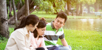 Q&A: How Can I Best Support My Child’s Withdrawal from Psychiatric Drugs? Asian mom and dad comforting daughter on grass in a park