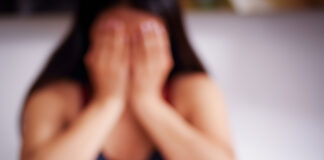 Close up of a blurred young woman covering her face