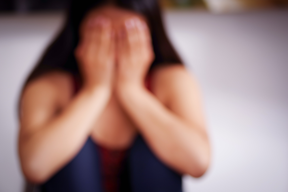 Close up of a blurred young woman covering her face