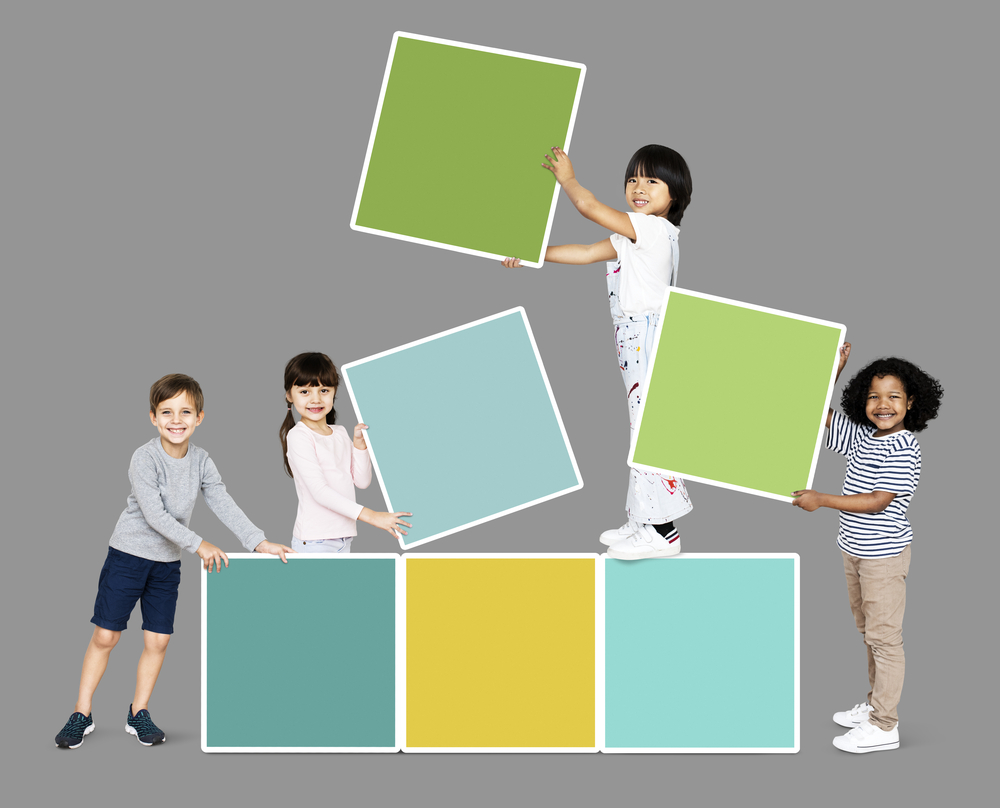 Diverse happy kids stacking empty square boards