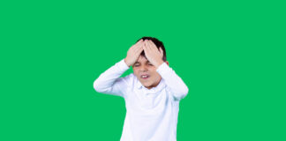 The Faulty Reasoning That Turned ADHD Into a Disease A boy is holding a head. He is unhappy and upset.