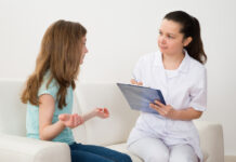 Researchers: ECT Study in Children Methodologically Flawed, Ethically Concerning Female Doctor Writing On Clipboard With Patient Sitting On Sofa