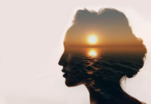 Beyond Psychiatry: A Trauma-Centric View of Mental Health A woman's head is silhouetted with the sunset over the water