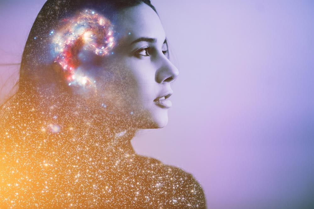 Multiple-exposure  portrait of a young woman's face with galaxy inside head