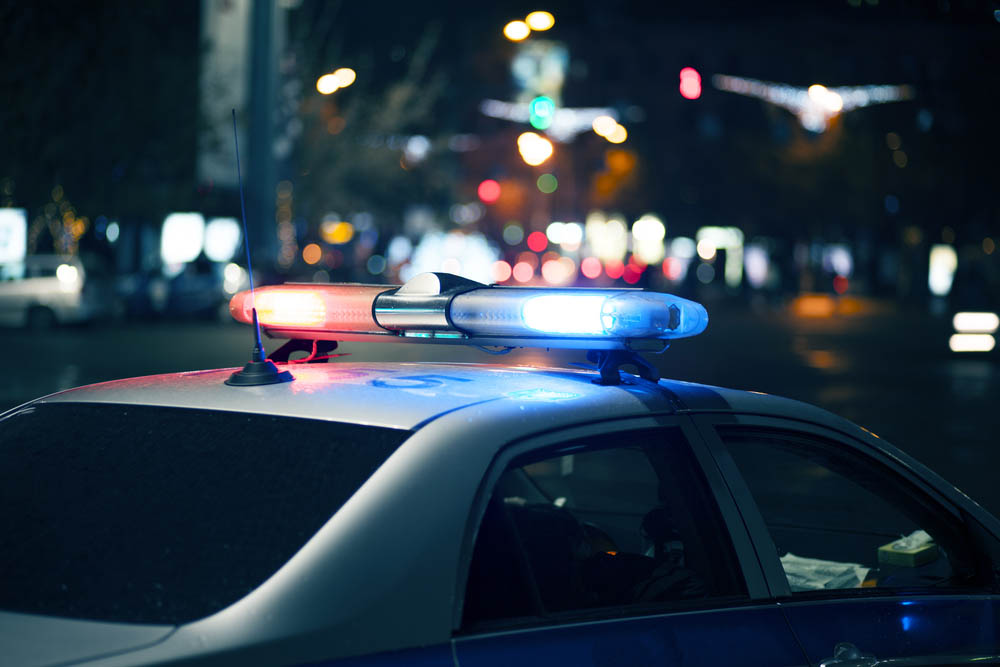 Photograph of the red and blue lights on top of a police car at night