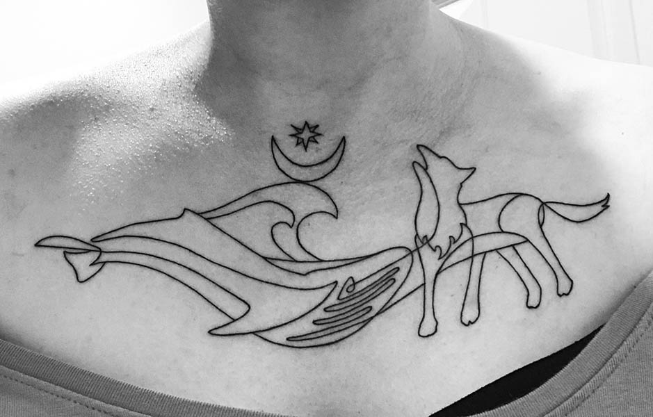 Black and white photo of a tattoo of a whale and a wolf