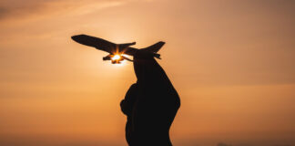 Can’t Be Trusted: A Book Review Review A hand holding a toy plane with sunset light